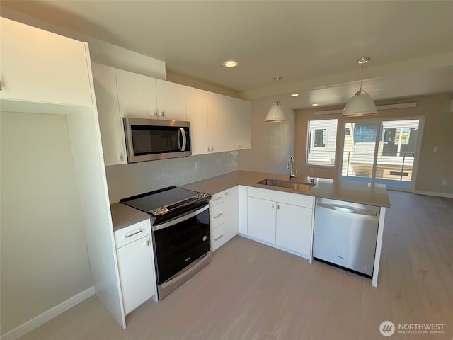 664 LOT25 W Kline Rd, Bellingham, WA 98226 - kitchen featuring appliances with stainless steel finishes, light wood-type flooring, a peninsula, white cabinets, and pendant lighting
