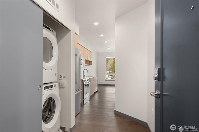 11903 NE 128th St Unit 205, Kirkland, WA 98034 - laundry room featuring stacked washing machine and dryer, dark wood-type flooring, and recessed lighting
