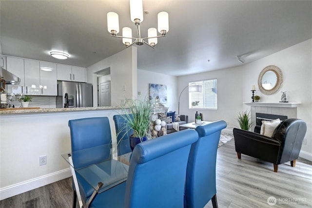 5000 Lake Washington Blvd NE Unit B201, Renton, WA 98056 - dining area featuring a chandelier, light wood-style flooring, and a tile fireplace