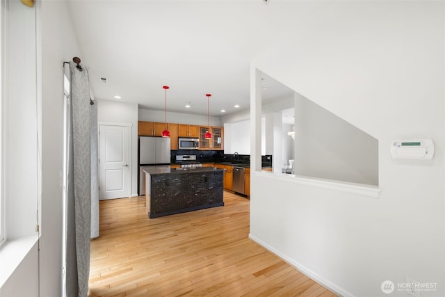 21270 40th Way S Unit 35, Seatac, WA 98198 - kitchen featuring stainless steel appliances, dark countertops, light wood-style flooring, recessed lighting, and a center island
