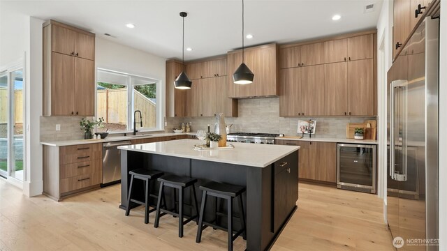 1118 N 34th St, Renton, WA 98056 - kitchen featuring beverage cooler, appliances with stainless steel finishes, a kitchen bar, a kitchen island, and modern cabinets