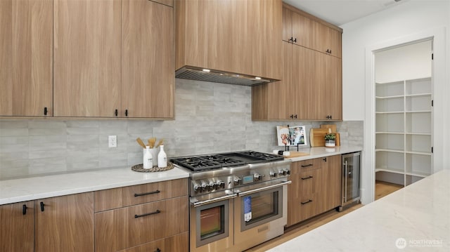 1118 N 34th St, Renton, WA 98056 - kitchen featuring double oven range, wine cooler, light stone countertops, tasteful backsplash, and wall chimney range hood