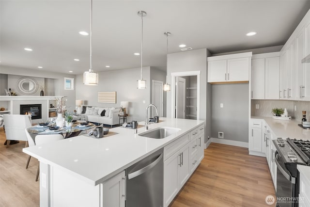 20851 156th St E, Bonney Lake, WA 98391 - kitchen featuring appliances with stainless steel finishes, open floor plan, white cabinets, recessed lighting, and light countertops