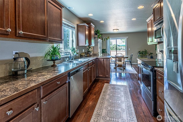 5003 Madison Heights Ct SE, Olympia, WA 98501 - kitchen with stainless steel appliances, dark wood finished floors, dark countertops, recessed lighting, and a textured ceiling
