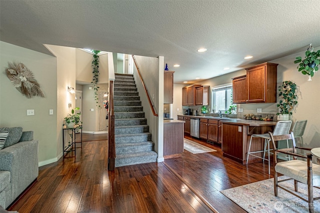 5003 Madison Heights Ct SE, Olympia, WA 98501 - kitchen with stainless steel dishwasher, brown cabinetry, dark wood-style flooring, a textured ceiling, and a peninsula