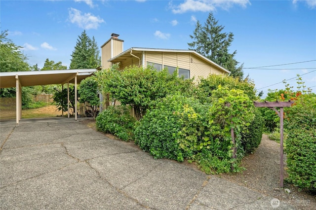 16654 SE 26th Pl, Bellevue, WA 98008 - view of side of property featuring a chimney, driveway, and an attached carport