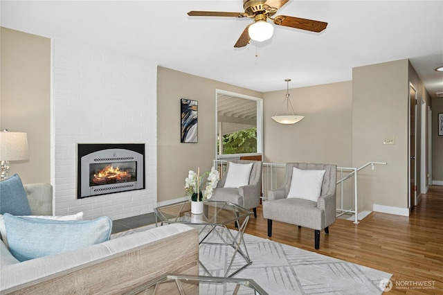 16654 SE 26th Pl, Bellevue, WA 98008 - living area featuring wood finished floors, a ceiling fan, and a fireplace