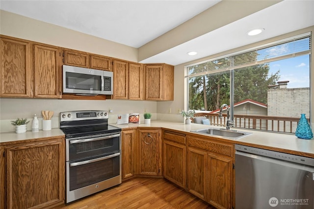 16654 SE 26th Pl, Bellevue, WA 98008 - kitchen with appliances with stainless steel finishes, light countertops, light wood-type flooring, brown cabinets, and recessed lighting