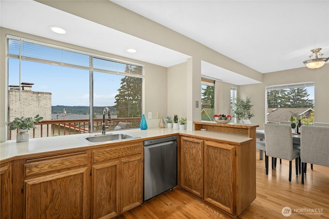 16654 SE 26th Pl, Bellevue, WA 98008 - kitchen featuring stainless steel dishwasher, light wood finished floors, light countertops, brown cabinets, and a peninsula