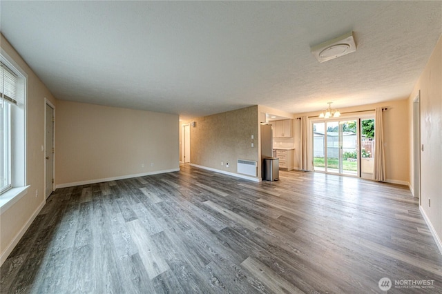 60 Crystal Ct, Sequim, WA 98382 - unfurnished living room featuring a chandelier, wood finished floors, and a textured ceiling