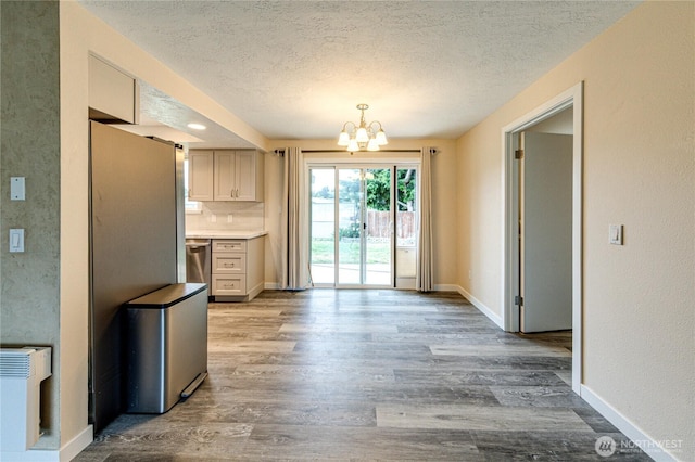 60 Crystal Ct, Sequim, WA 98382 - kitchen featuring a textured ceiling, a chandelier, wood finished floors, stainless steel dishwasher, and light countertops