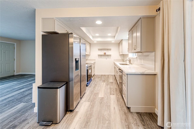 60 Crystal Ct, Sequim, WA 98382 - kitchen featuring appliances with stainless steel finishes, light wood-style flooring, a tray ceiling, light stone countertops, and recessed lighting