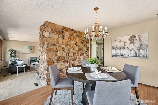 5415 Johnson Point Rd NE, Olympia, WA 98516 - dining space featuring light wood-style flooring, a chandelier, and a textured ceiling