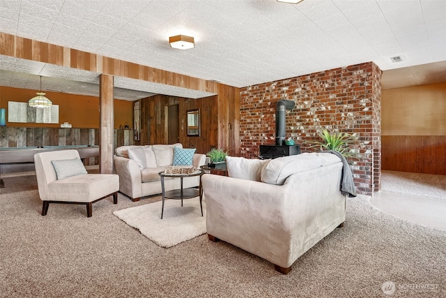 5415 Johnson Point Rd NE, Olympia, WA 98516 - carpeted living room featuring wood walls, a wood stove, and a wainscoted wall