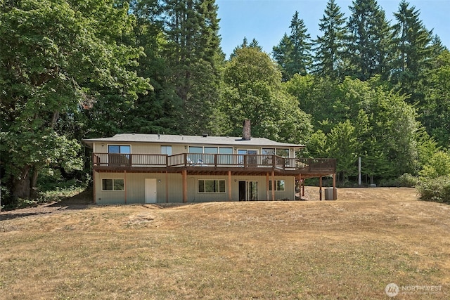 5415 Johnson Point Rd NE, Olympia, WA 98516 - back of house with a lawn, a wooden deck, a chimney, and a wooded view