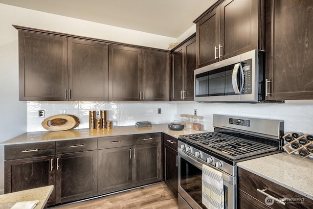 28003 74th Ave NW Unit 33, Stanwood, WA 98292 - kitchen featuring stainless steel appliances, light stone counters, tasteful backsplash, and dark brown cabinetry