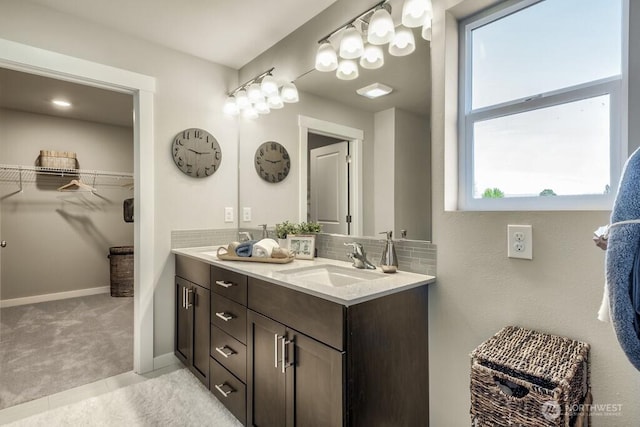 28003 74th Ave NW Unit 33, Stanwood, WA 98292 - full bathroom featuring double vanity, a walk in closet, and tasteful backsplash