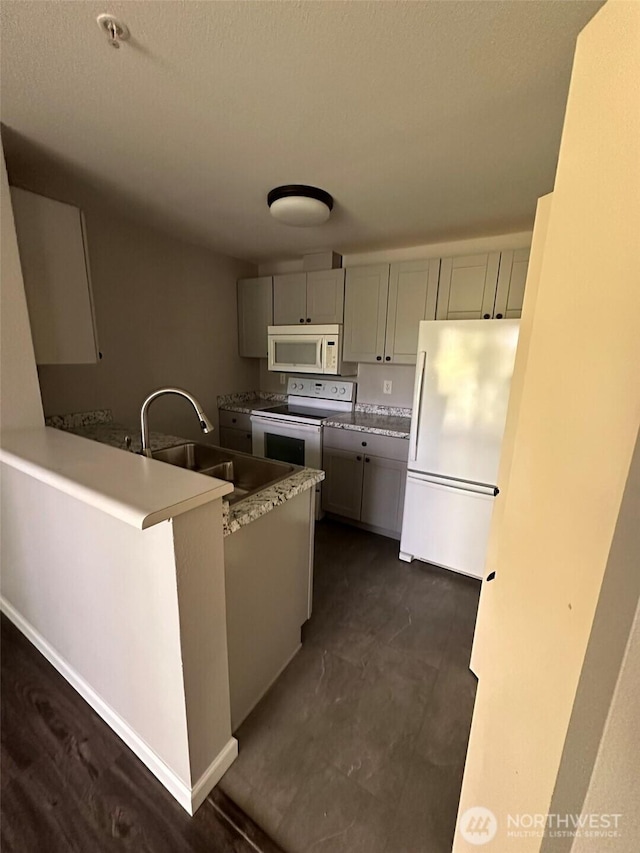 11002 SE Petrovitsky Rd Unit F302, Renton, WA 98055 - kitchen featuring white appliances, gray cabinetry, a peninsula, and light countertops
