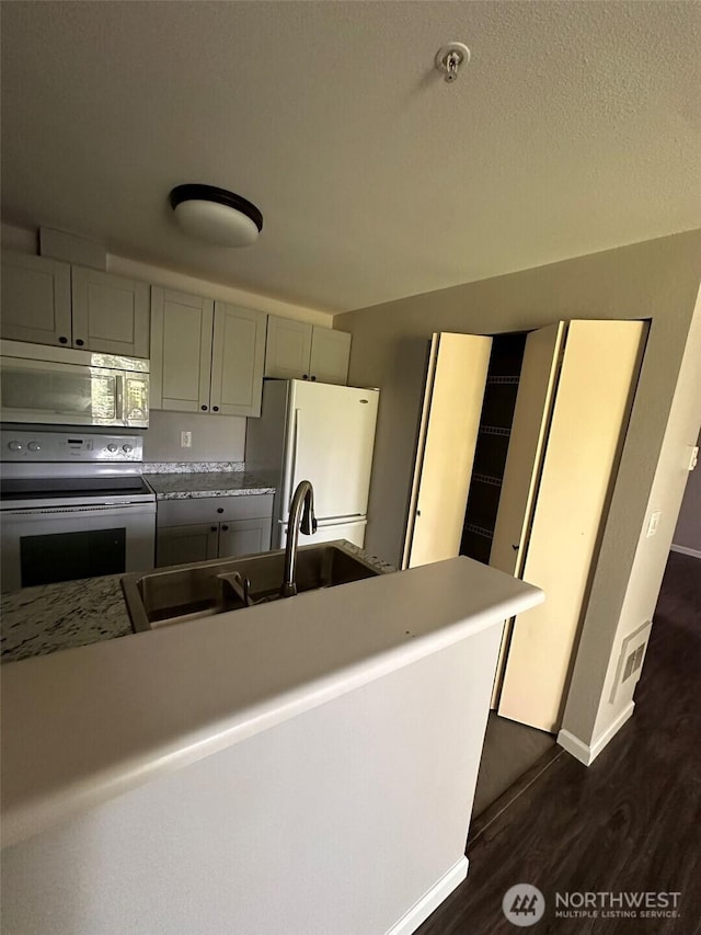 11002 SE Petrovitsky Rd Unit F302, Renton, WA 98055 - kitchen with white appliances, dark wood-style floors, gray cabinets, and light countertops