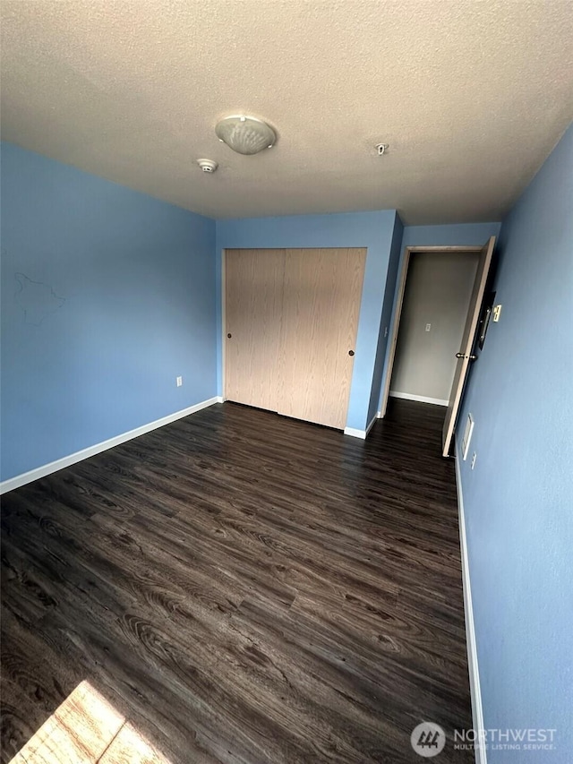 11002 SE Petrovitsky Rd Unit F302, Renton, WA 98055 - unfurnished bedroom with dark wood-style flooring, a textured ceiling, and a closet