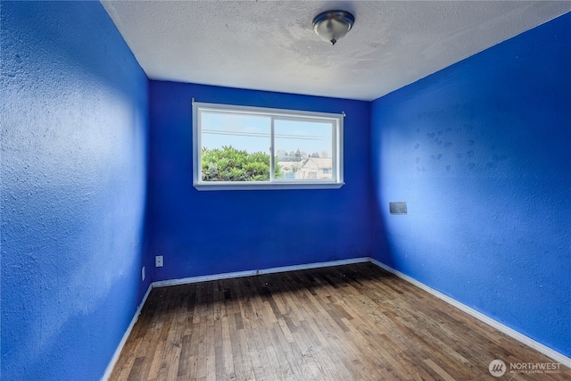 11846 SE 170th Pl, Renton, WA 98258 - spare room with a textured wall, wood-type flooring, and a textured ceiling