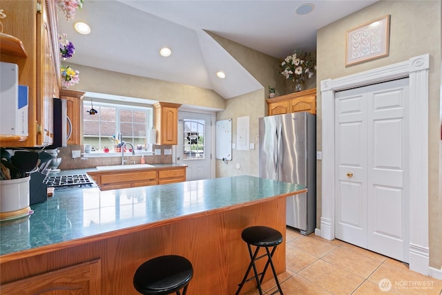302 S Washington, Everson, WA 98247 - kitchen with stainless steel appliances, a peninsula, light tile patterned flooring, a kitchen breakfast bar, and lofted ceiling