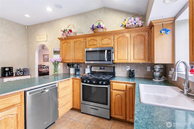 302 S Washington, Everson, WA 98247 - kitchen featuring appliances with stainless steel finishes, light tile patterned floors, decorative backsplash, lofted ceiling, and arched walkways