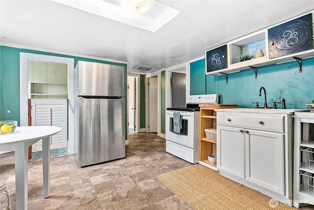 1814 Wilson Ave, Bellingham, WA 98225 - kitchen with freestanding refrigerator, white electric stove, open shelves, white cabinets, and stone finish flooring