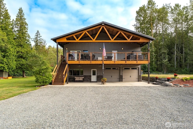3148 Mountain View Rd, Ferndale, WA 98248 - view of front facade featuring concrete driveway, an attached garage, stairs, stone siding, and a wooden deck