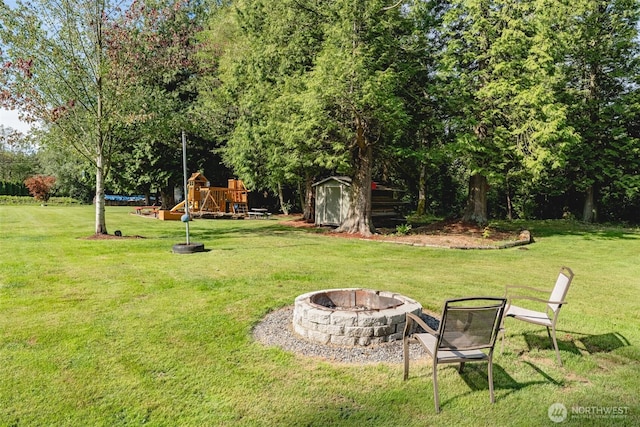 3148 Mountain View Rd, Ferndale, WA 98248 - view of green lawn with an outdoor fire pit, a storage unit, and a playground