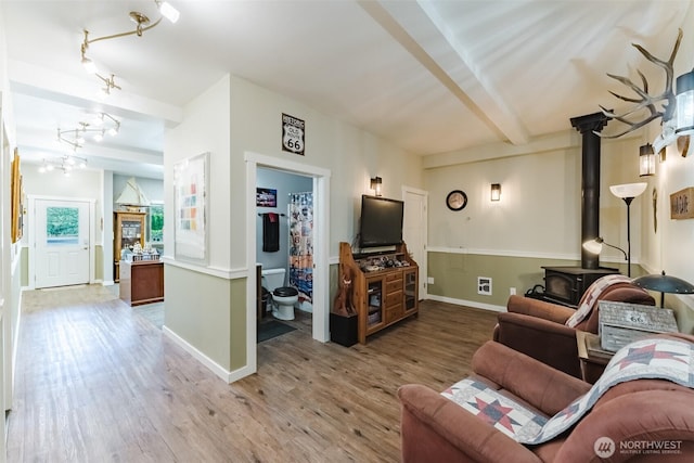 3148 Mountain View Rd, Ferndale, WA 98248 - living area with a wood stove, light wood-style flooring, rail lighting, and beamed ceiling