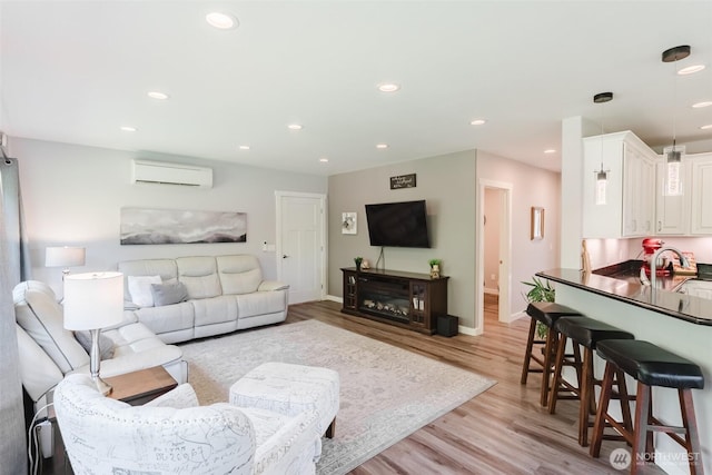 3148 Mountain View Rd, Ferndale, WA 98248 - living room with a wall unit AC, light wood-style floors, recessed lighting, and a glass covered fireplace