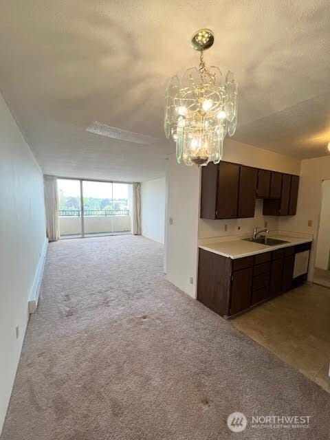 4540 8th Ave NE Unit 903, Seattle, WA 98105 - kitchen featuring dark brown cabinets, a chandelier, light colored carpet, open floor plan, and light countertops