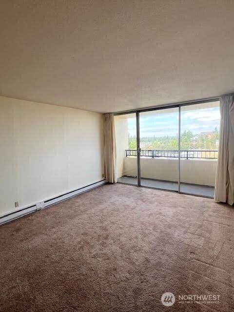 4540 8th Ave NE Unit 903, Seattle, WA 98105 - unfurnished room featuring a baseboard heating unit and carpet