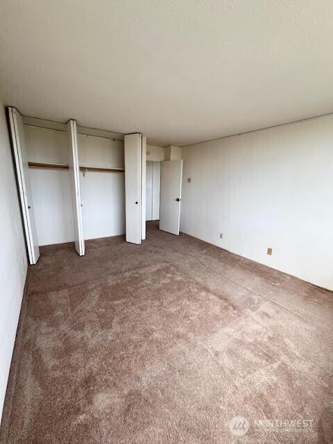 4540 8th Ave NE Unit 903, Seattle, WA 98105 - unfurnished bedroom with carpet and multiple closets