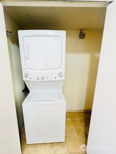 4540 8th Ave NE Unit 903, Seattle, WA 98105 - laundry room with stacked washer and clothes dryer and light tile patterned floors