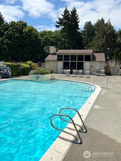 4540 8th Ave NE Unit 903, Seattle, WA 98105 - community pool with a patio area, view of scattered trees, and an outdoor structure