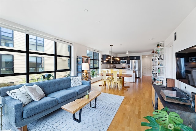 4116 California Ave SW Unit 309, Seattle, WA 98116 - living room featuring light wood-style flooring and a chandelier