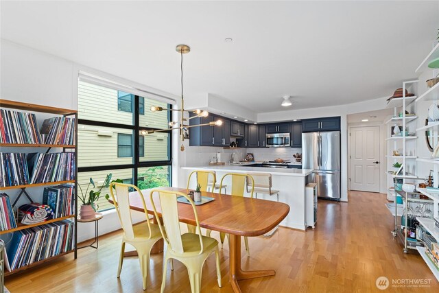 4116 California Ave SW Unit 309, Seattle, WA 98116 - dining space featuring light wood-type flooring and a chandelier