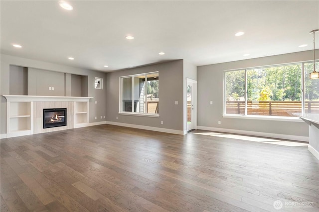 20837 156th St E, Bonney Lake, WA 98391 - unfurnished living room with healthy amount of natural light, wood finished floors, recessed lighting, and a tiled fireplace