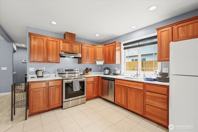 919 4th Ave N, Kent, WA 98032 - kitchen with stainless steel appliances, under cabinet range hood, light countertops, brown cabinetry, and recessed lighting