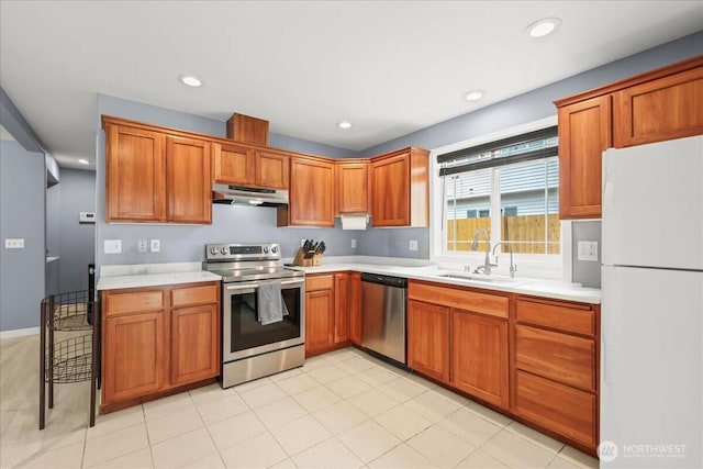 919 4th Ave N, Kent, WA 98032 - kitchen with appliances with stainless steel finishes, under cabinet range hood, light countertops, brown cabinets, and recessed lighting