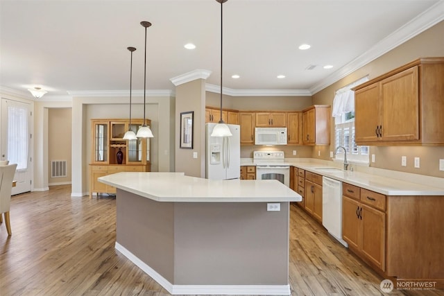 4826 Bend Dr NE, Lacey, WA 98516 - kitchen with white appliances, crown molding, a center island, light wood finished floors, and light countertops
