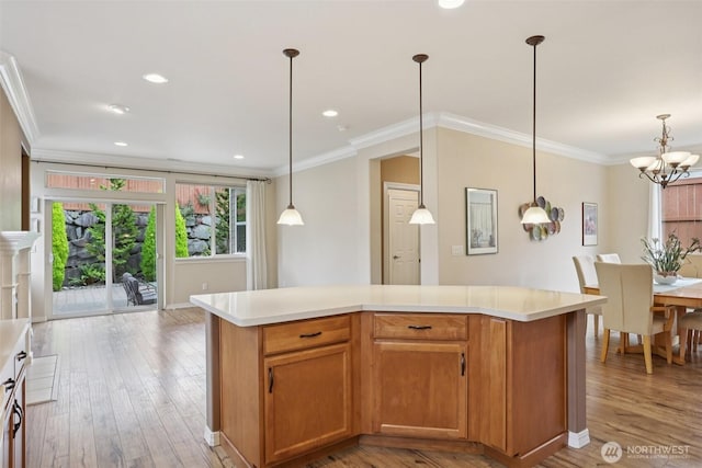 4826 Bend Dr NE, Lacey, WA 98516 - kitchen with light countertops, light wood-type flooring, a chandelier, ornamental molding, and pendant lighting