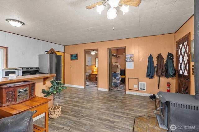 30710 223rd Ave NE, Arlington, WA 98223 - living room featuring wood finished floors, ceiling fan, a wood stove, and heating unit