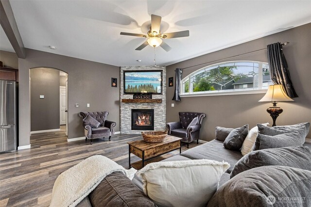 7726 162nd St E, Puyallup, WA 98375 - living area featuring arched walkways, ceiling fan, wood finished floors, and a stone fireplace