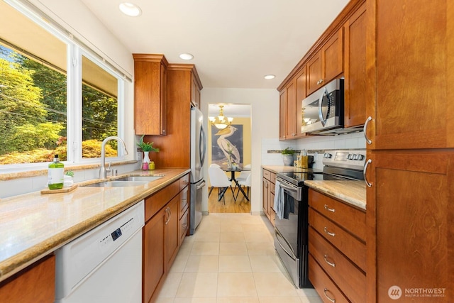 132 NE 130th St, Seattle, WA 98125 - kitchen featuring appliances with stainless steel finishes, a chandelier, light stone countertops, tasteful backsplash, and recessed lighting