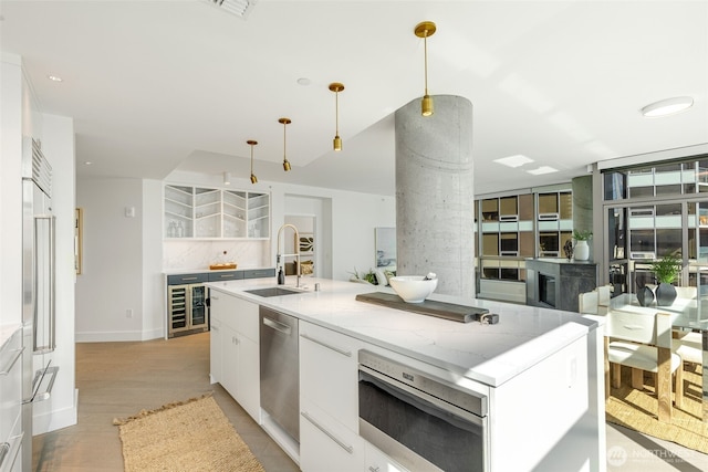 2033 2nd Ave Unit 1111, Seattle, WA 98121 - kitchen featuring dishwasher, white cabinets, light stone countertops, pendant lighting, and a large island with sink