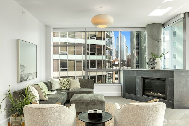 2033 2nd Ave Unit 1111, Seattle, WA 98121 - living room featuring wood finished floors, a view of skyline, and a glass covered fireplace