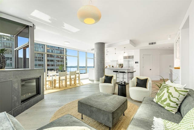 2033 2nd Ave Unit 1111, Seattle, WA 98121 - living room with light wood-style floors, a water view, and a glass covered fireplace